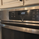 GE oven with blinking clock display in real home kitchen