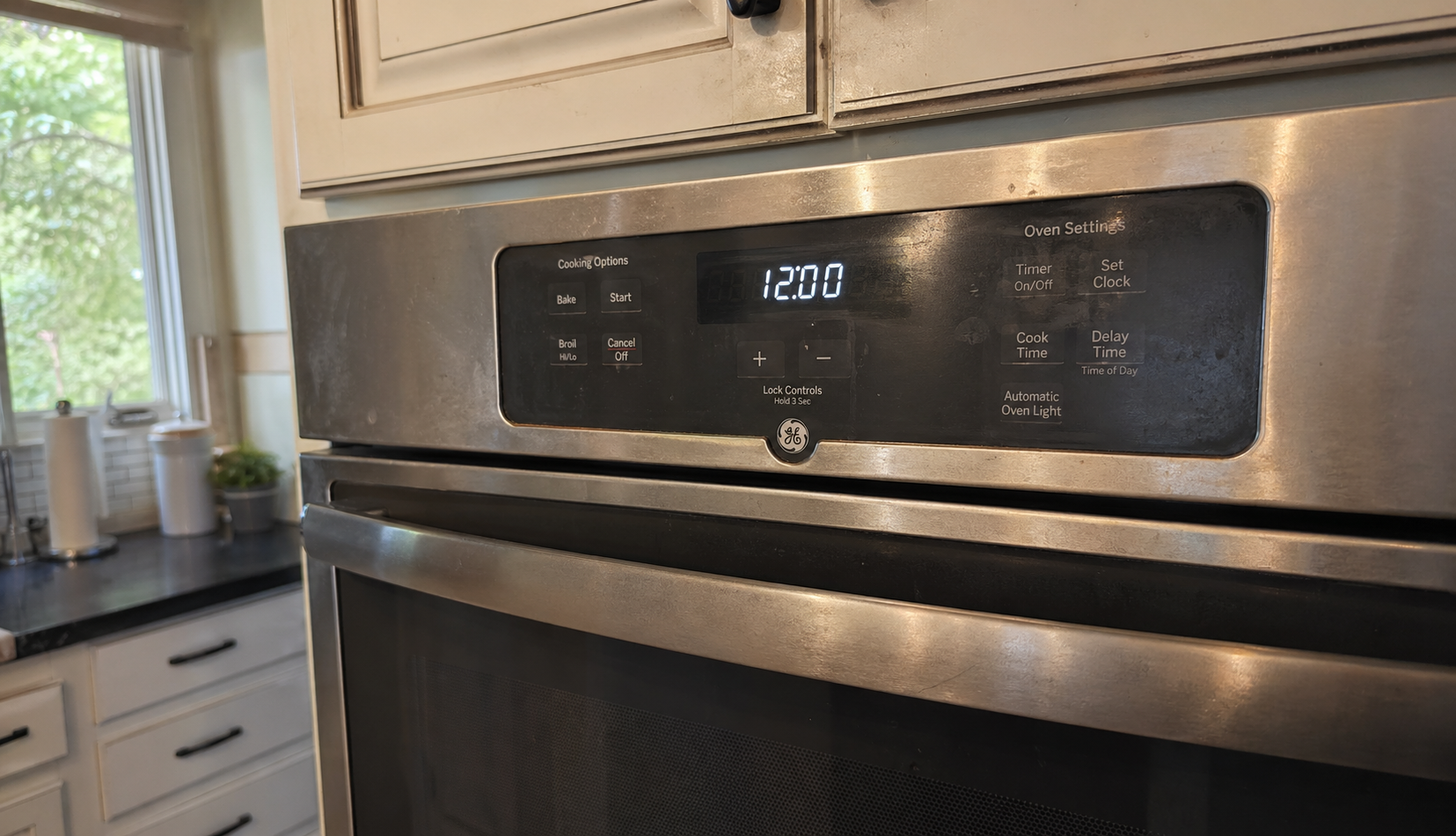 GE oven with blinking clock display in real home kitchen