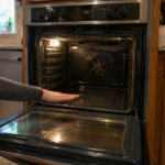 Hand checking inside cold oven cavity during heating problem diagnosis