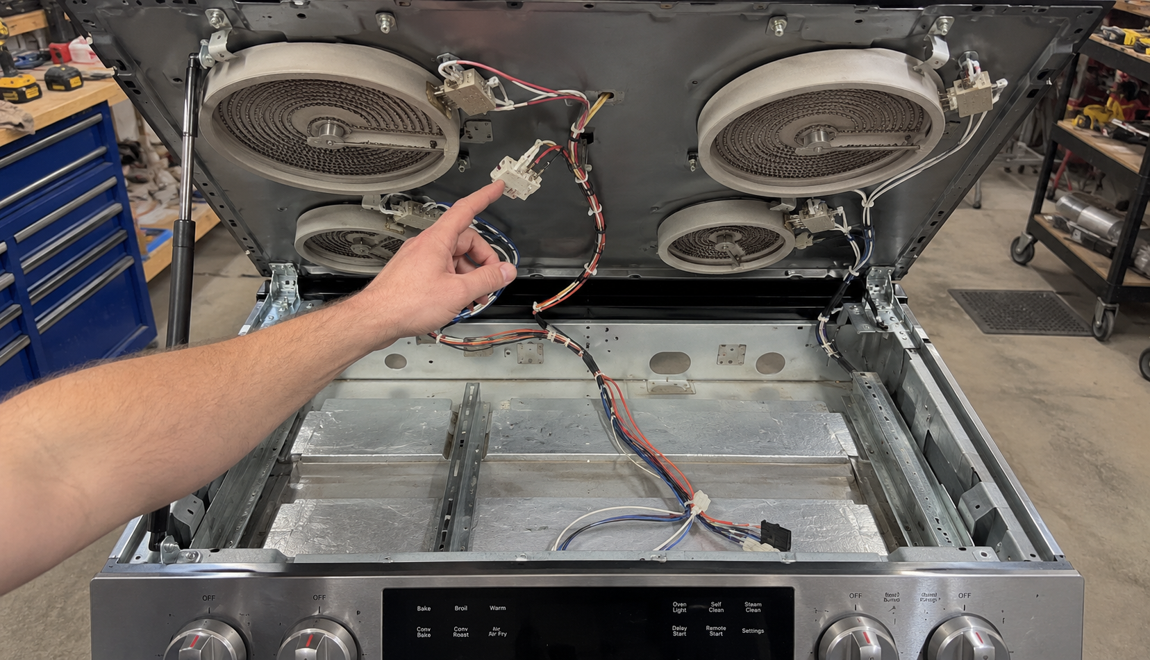 ChatGPT Image Jun 12, 2026, 04_14_19 PM Range top hinged open showing radiant elements and wiring harness underneath