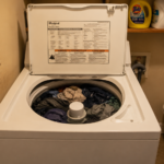 Open top load washing machine full of wet clothes stopped mid spin cycle