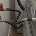 kinked water supply hose behind washing machine