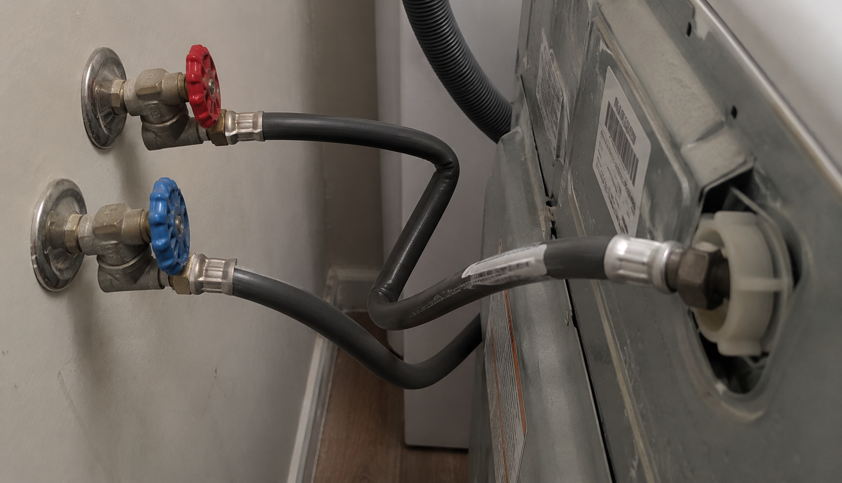 kinked water supply hose behind washing machine