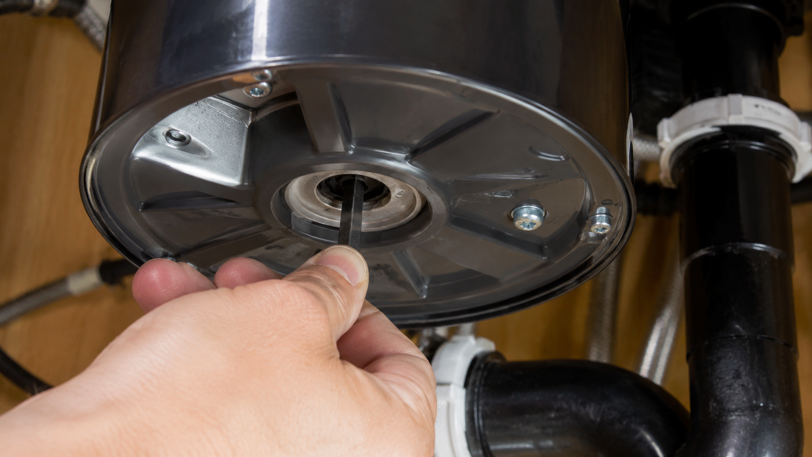 ChatGPT Image Jun 25, 2026, 04_16_36 PM (2) using Allen wrench to clear jam in garbage disposal