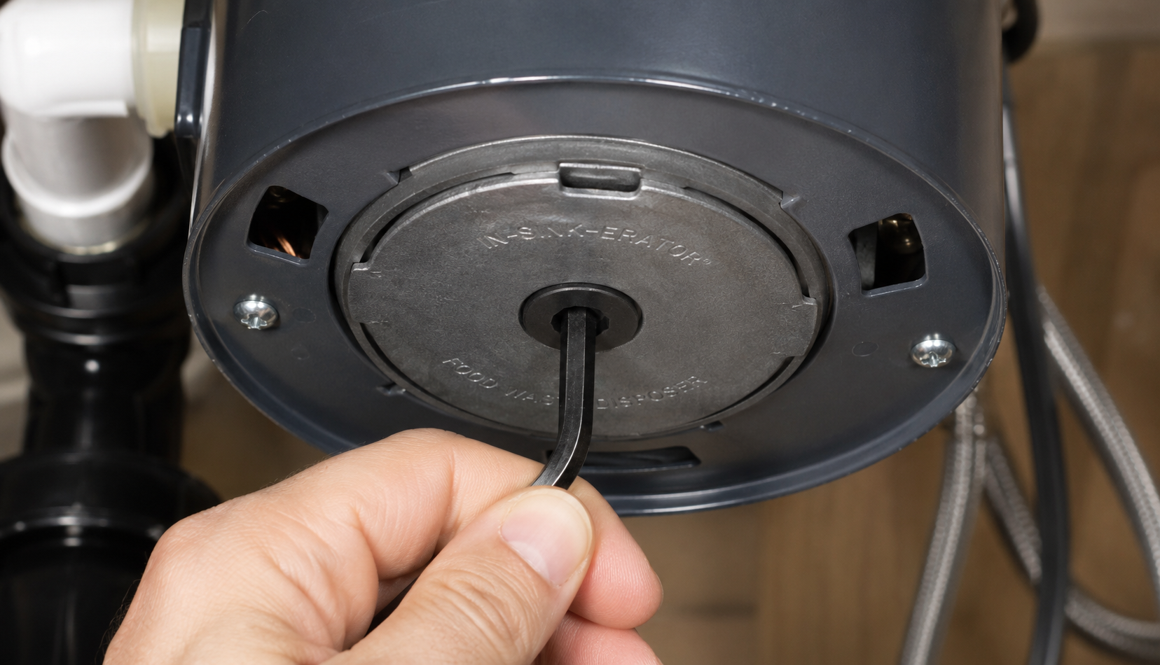 ChatGPT Image Jun 27, 2026, 11_07_36 PM using Allen wrench to free jammed garbage disposal flywheel