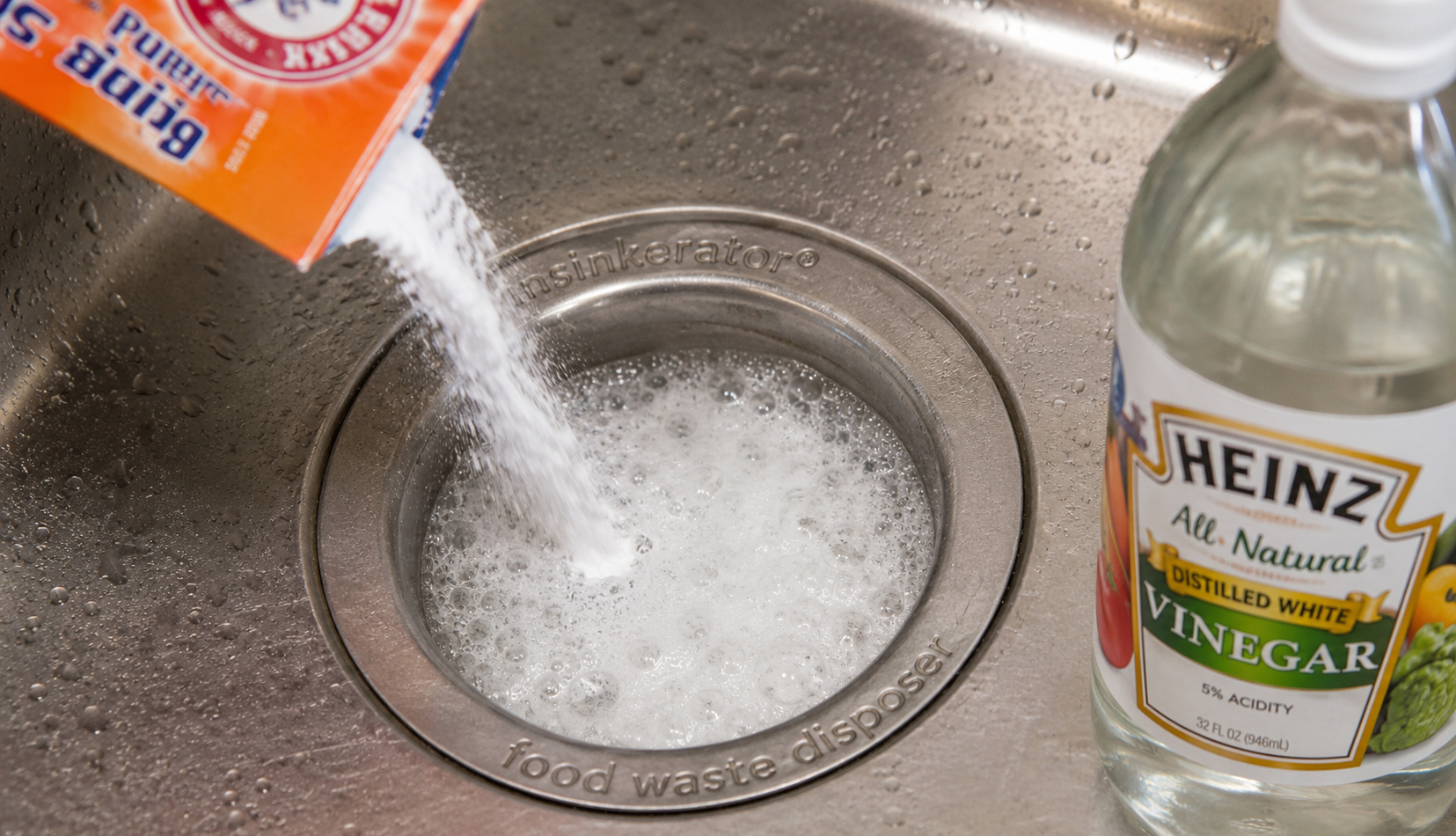 Baking soda and vinegar fizzing reaction in garbage disposal drain for natural cleaning