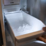 Empty ice bin with clumped ice inside a Samsung freezer compartment