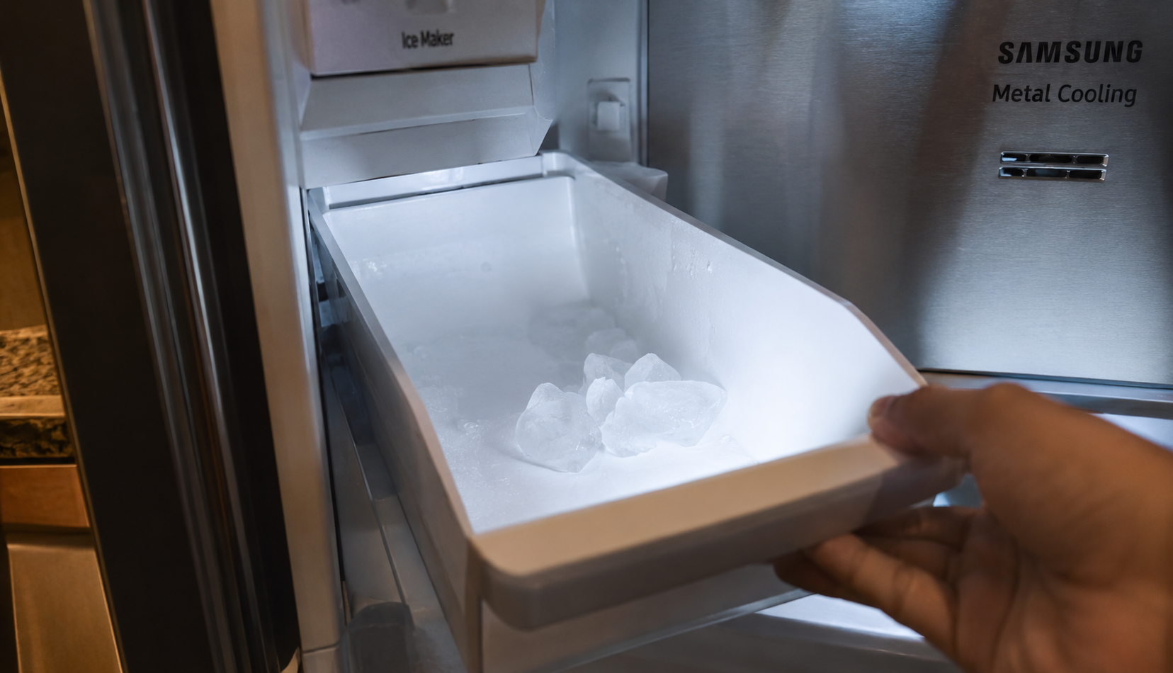 Empty ice bin with clumped ice inside a Samsung freezer compartment