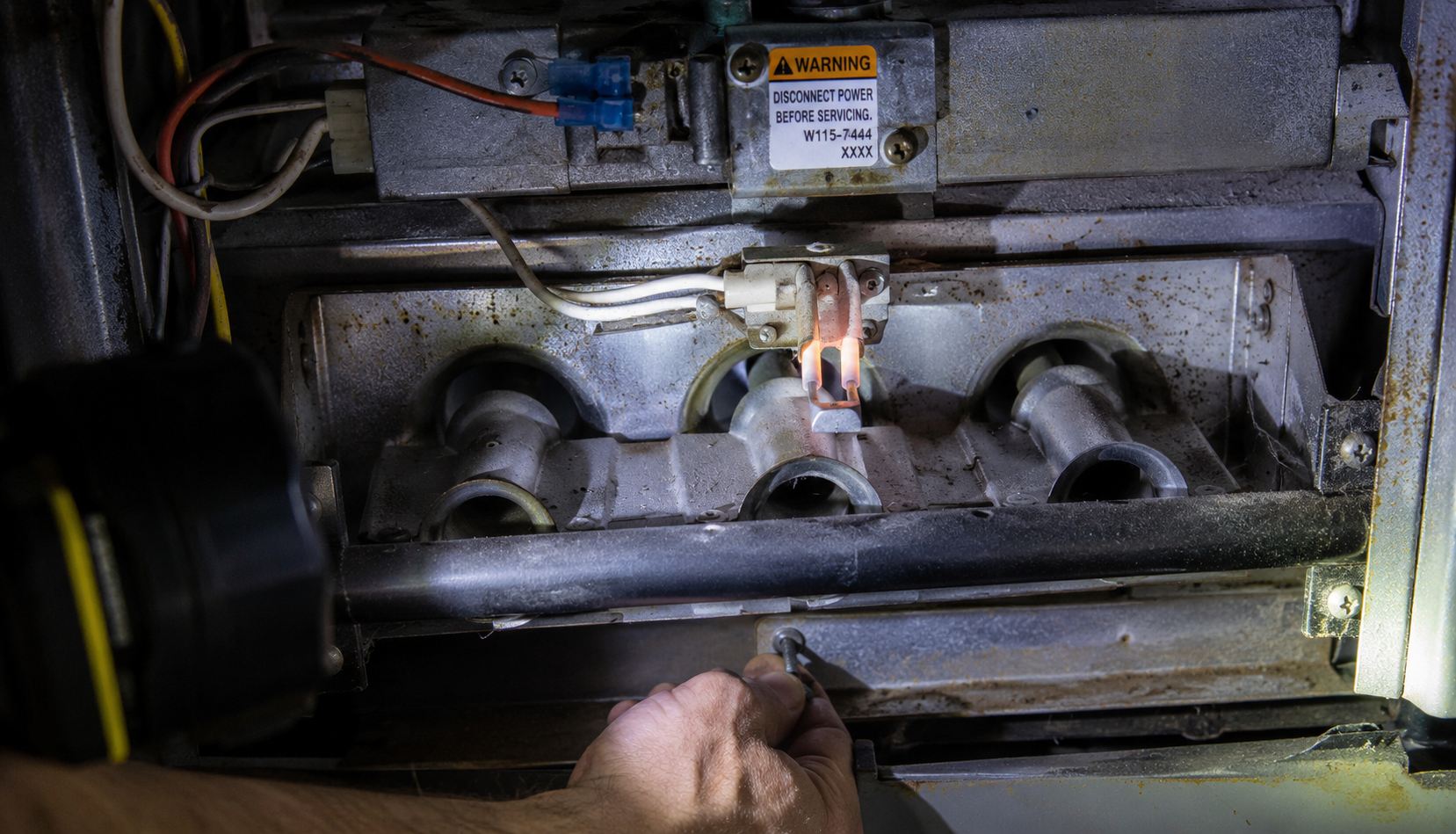 Close-up of furnace ignitor and burner assembly during inspection